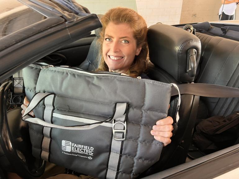 During last year's meeting, Catherine Graham of Blythewood was all smiles after receiving her cooler tote bag gift for registration. This year, members will receive a folding bag chair when they register and vote.