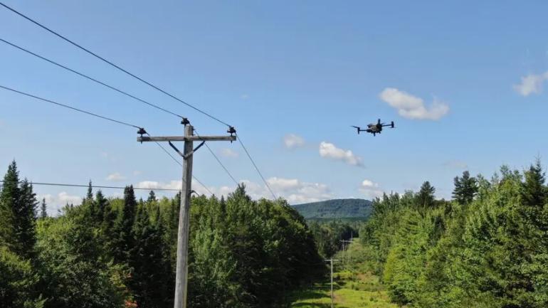 photo of drone flying near power pole